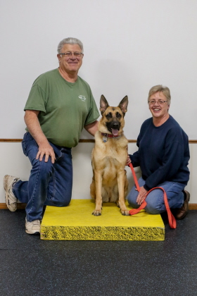 German Shepherd poses with owners for obedience class photo