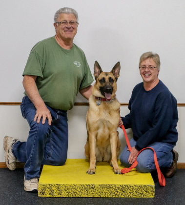 German Shepherd poses with owners for obedience class photo